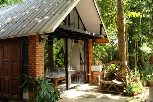 a brick house with a glass door and a sink at Ashi Guesthouse Chiangdao in Chiang Dao
