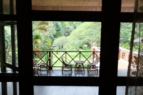 a window view of a porch with chairs and a table at Ashi Guesthouse Chiangdao in Chiang Dao
