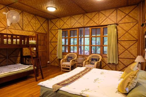 a bedroom with a bunk bed and a bunk room with a ladder at Ashi Guesthouse Chiangdao in Chiang Dao