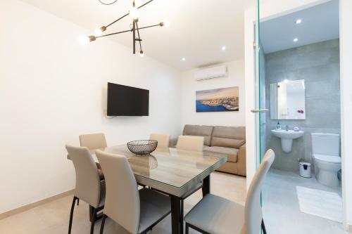 - une salle à manger avec une table, des chaises et un canapé dans l'établissement FL56 - New 3storey House - private entrance & roof, à Il-Furjana