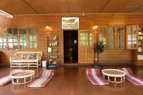 a living room with a couch and a table and chairs at Ashi Guesthouse Chiangdao in Chiang Dao
