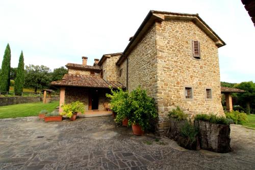 an old stone building with plants in a courtyard at Casale Lorenzo in Subbiano