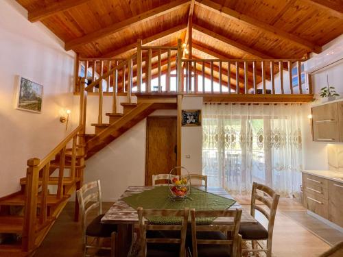 uma sala de jantar com uma mesa e uma escada em River Escape Villa - Private Beach, Scenic view & BBQ em Tepelenë