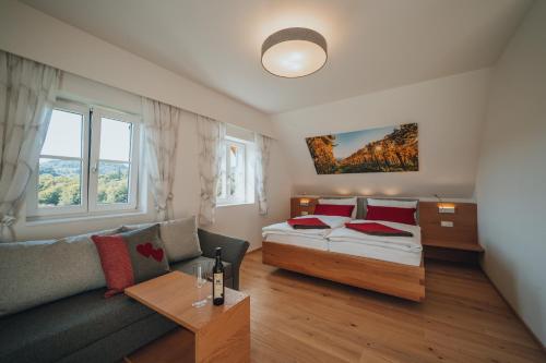 a bedroom with a bed and a couch at Weinquartier Pichler-Schober in Mitteregg