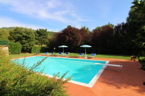 a swimming pool with chairs and umbrellas at Casale Lorenzo in Subbiano