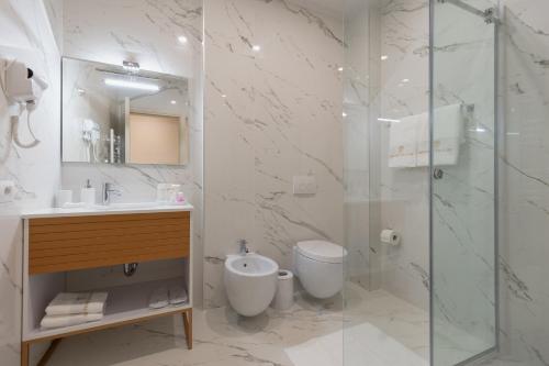 a bathroom with a shower and a toilet and a sink at Hotel Boutique Vila 135 in Tirana