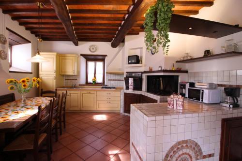 a large kitchen with a table and a dining room at Casale Lorenzo in Subbiano