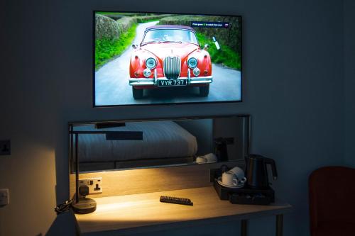a tv hanging on a wall with a car on it at Byron Hotel in London