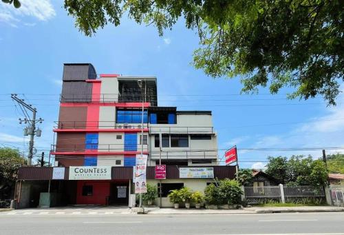 a building with a red white and blue at CounTess Pension House in Liloan