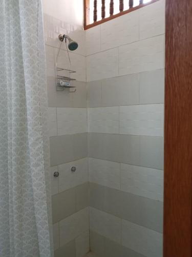 a bathroom with a shower with a shower curtain at LA CABAÑA DE HUERTAMAR in Zorritos