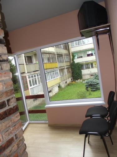 a room with two chairs and a large window at Nakvynė Rokiškyje in Rokiškis