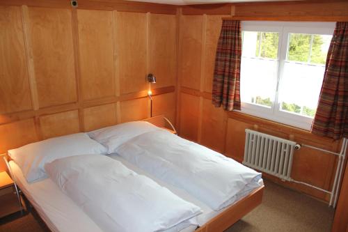 a small bedroom with a bed with a window at Chalet Good in Flumserberg