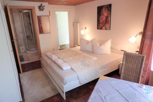 ein Schlafzimmer mit einem Bett und ein Badezimmer mit einer Dusche in der Unterkunft Frühstückspension Mayer-Schiller in Bernried