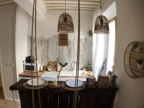 une cuisine avec un comptoir et trois lampes suspendues dans l'établissement LE BALI, T2, Hyper centre, à Mâcon