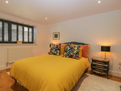 a bedroom with a yellow bed and a window at Frith Green in Bromyard