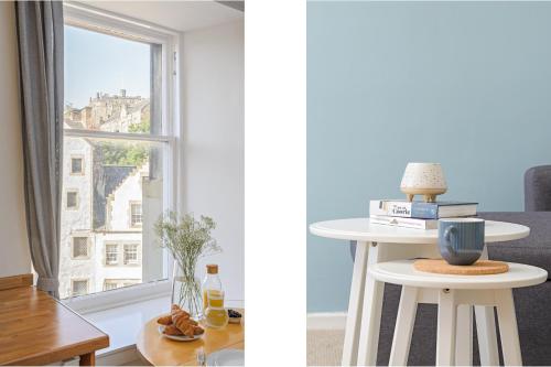 a living room with a window and a table with books at The West Bow View Apartment in Edinburgh