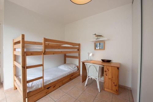 une chambre avec un lit superposé et un bureau dans l'établissement Un sejour a huit dans cette grande maison a Saint Gilles Croix de Vie, à Saint-Gilles-Croix-de-Vie