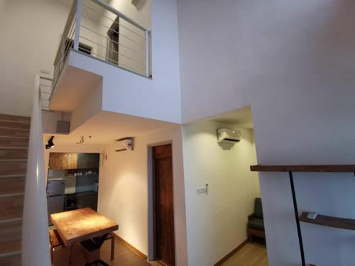 a room with a staircase and a room with a table at ExcluSuites Malacca @ The Wave Residence in Melaka