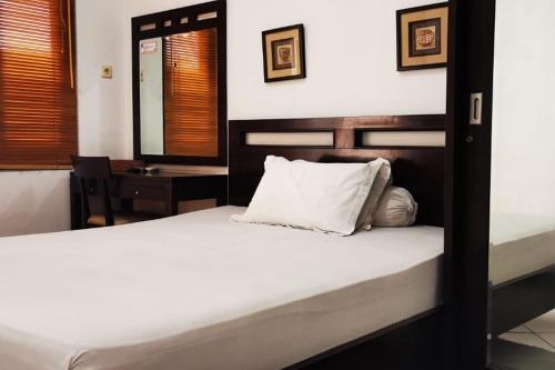 Ngawinan的住宿－Dinnar Homestay Gayungan Mitra RedDoorz，一间卧室配有两张床和一张带镜子的桌子