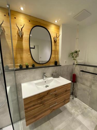 a bathroom with a sink and a mirror at Ferienwohnung Lisl in Holzkirchen