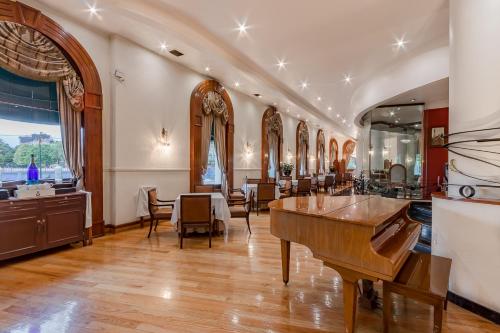Habitación grande con salón con mesas y sillas. en Hotel Imperial Reforma, en Ciudad de México