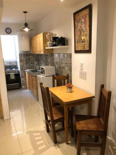 a kitchen with a wooden table and chairs in a room at Departamento 1 ambiente Excelente ubicación en Mar del Plata in Mar del Plata