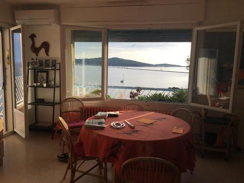 une salle à manger avec une table et une grande fenêtre dans l'établissement La Mitre, à Toulon
