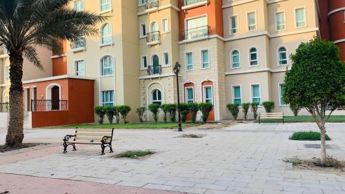 a park with benches in front of a building at Expo Backpackers in Dubai