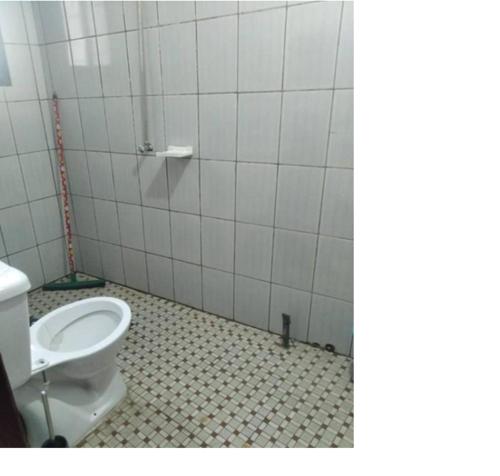 a bathroom with a toilet and a tiled floor at Appartements meublés Sorel in Douala
