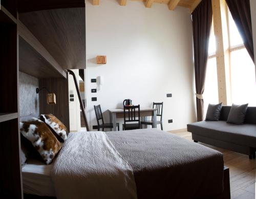 a bedroom with a bed and a table and chairs at Alpenrooms in Transacqua