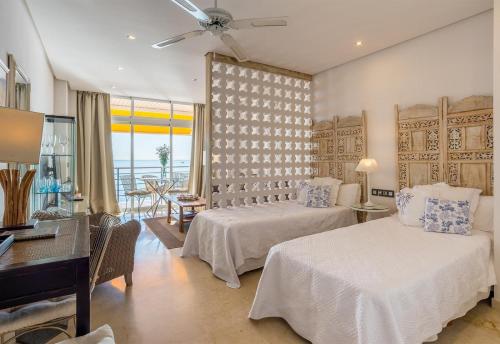 sypialnia z 2 łóżkami i biurkiem z pianinem w obiekcie Sunny View Castillo Santa Clara w mieście Torremolinos