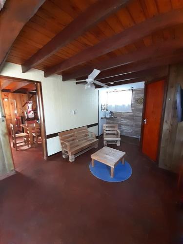 a living room with a table and a bench at Cabañas Estrellas Doradas in Miramar