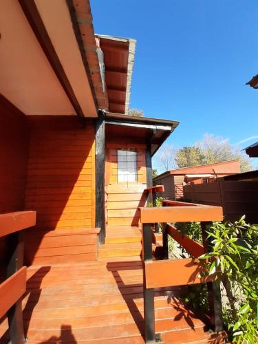 a building with a wooden deck with a bench at Cabañas Estrellas Doradas in Miramar