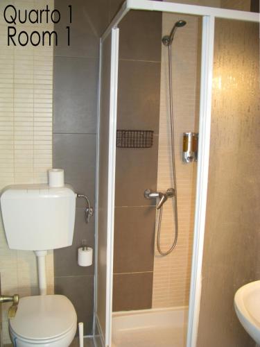 a bathroom with a shower with a toilet and a sink at Alojamento Tiago & Jorge Guesthouse in Nazaré