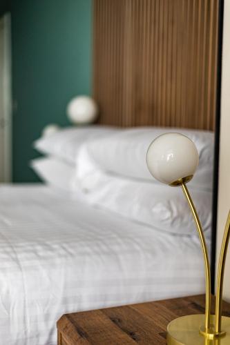a lamp on a table next to a bed at Ty Belgrave - Apartment 2 in Aberystwyth