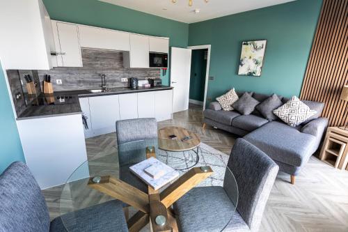 a living room with a couch and a table at Ty Belgrave - Apartment 2 in Aberystwyth