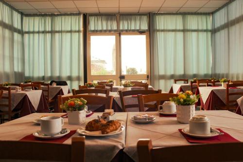 a dining room with tables and chairs with food on them at Hotel Garden Napoli in Naples