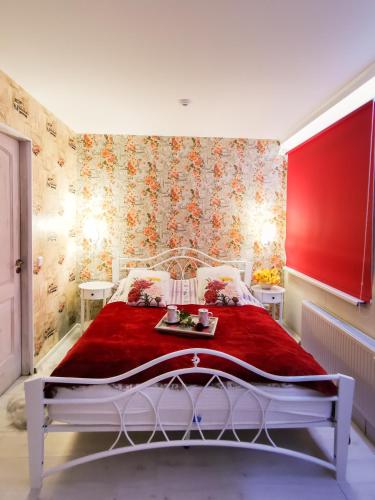 a bedroom with a red bed with a red blanket at Central Riverside Apartments in Jēkabpils