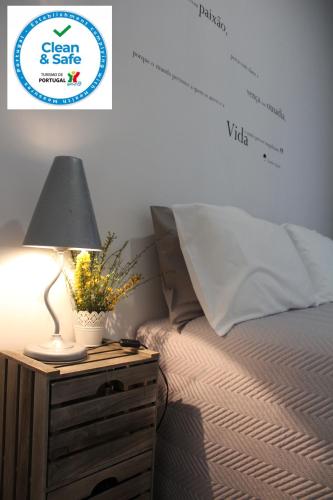 a lamp on a night stand next to a bed at Casa do Rio - Penacova in Raiva