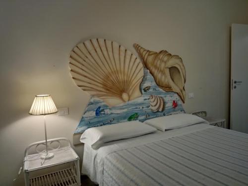 Un dormitorio con una cama con un gran cabezal de caparazón en Villa Carol "Ortensia1" "Ortensia 2" en Tollo