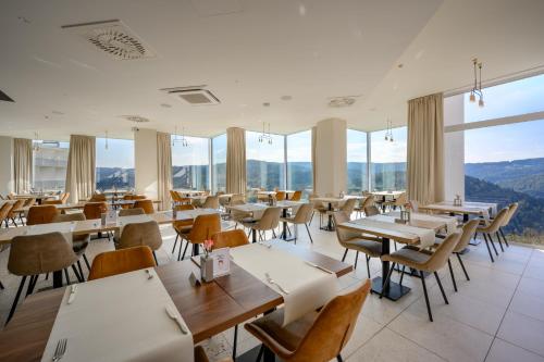 a restaurant with tables and chairs and large windows at Crystal Mountain Hotel Wisła in Wisła