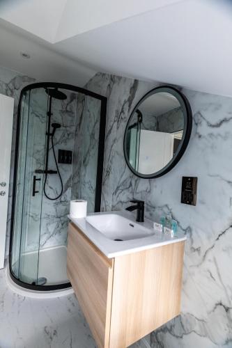 a bathroom with a sink and a mirror at Ty Belgrave - Apartment 4 in Aberystwyth