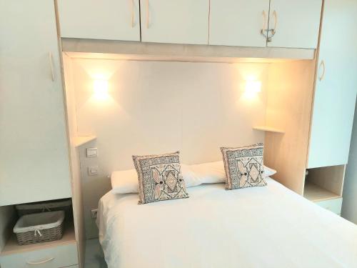 una camera con un letto con due cuscini sopra di Plage la Salis 3 chambres, Jardin - 3 bedrooms a Antibes