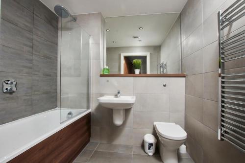 a bathroom with a sink and a toilet and a tub at Central Manchester 2 Bed - Parking - Sleeps 4 in Manchester