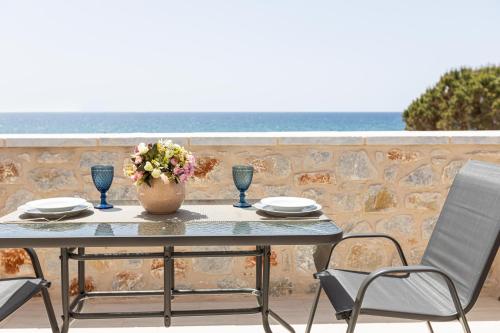 a table with two chairs and a vase with flowers on it at Elaianthos 2 in Gythio