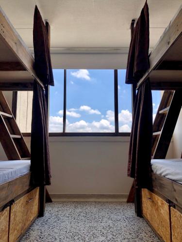 two bunk beds in a room with a window at Mae's Skate House in Cali