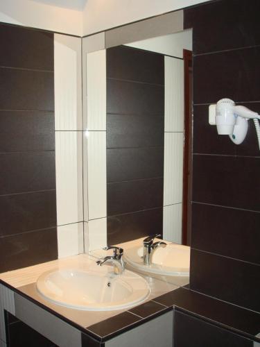 a bathroom with a sink and a mirror at Platán Panzió in Nagyszénás
