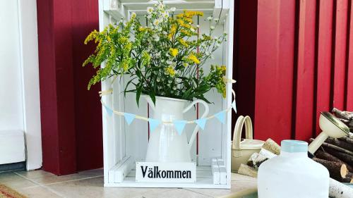een witte vaas gevuld met bloemen op een deur bij Hyggeliges Ferienhaus am Waldrand „das Filznhaus“ in Raubling