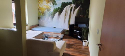 a living room with a painting of a waterfall at Ferienwohnung Golden Lotus in Neuwied