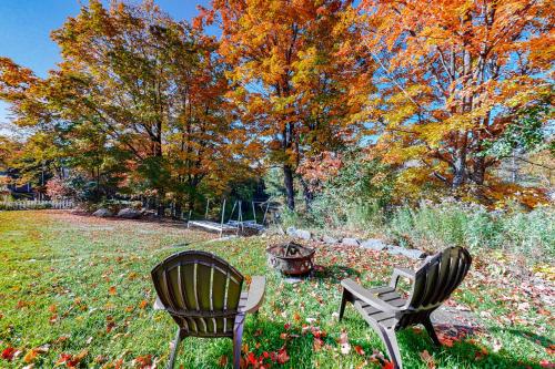 two chairs and a table in a field with trees at Wiggin Stream Camp in Greenville